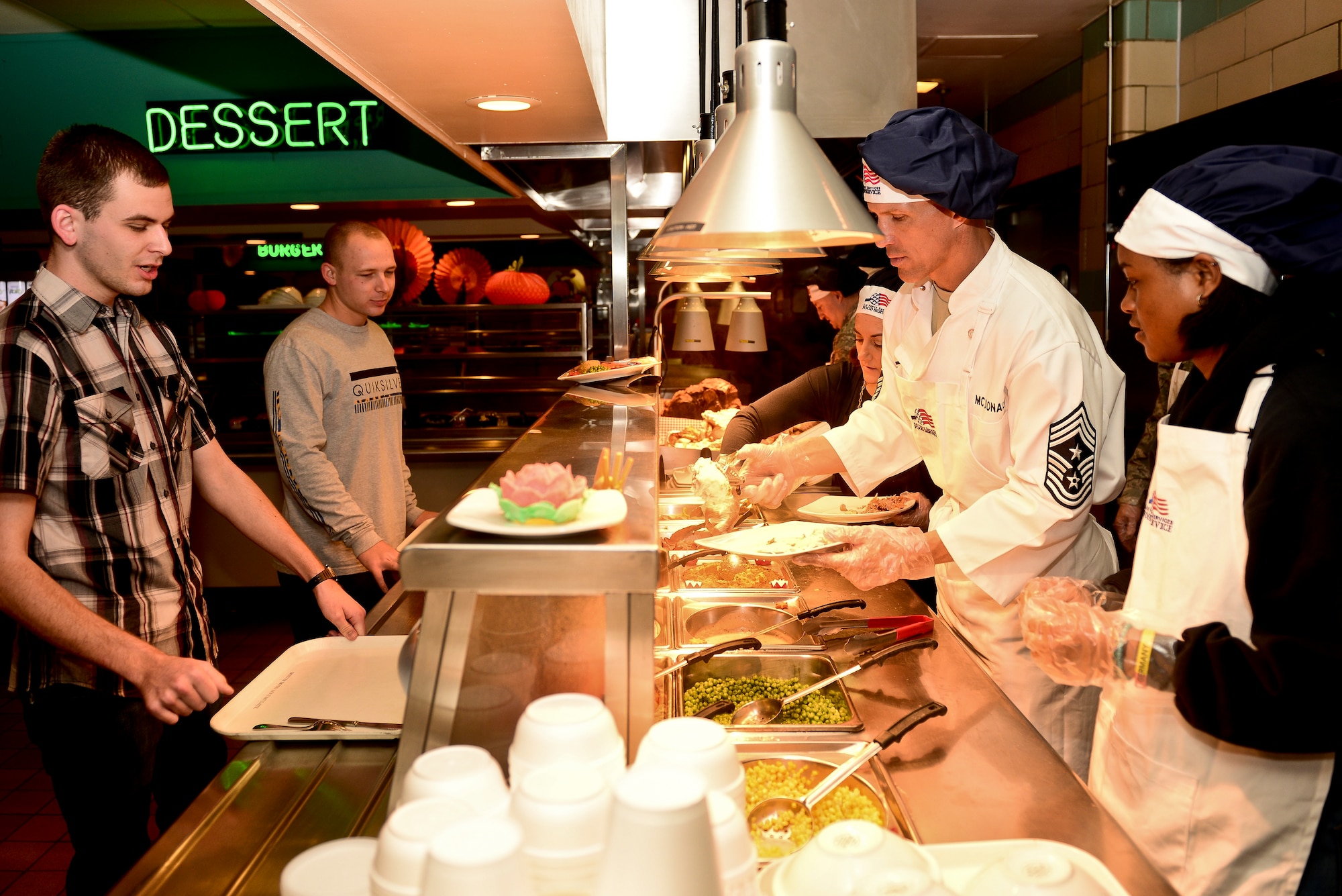 U.S. Air Force Chief Master Sgt. Steve McDonald, the command chief of Air Combat Command, serves a Thanksgiving meal to Airmen at Langley Air Force Base, Va., Nov. 26, 2015. The meal was served to help Service members who could not go home during the holiday. Langley leadership served them a traditional Thanksgiving meal including turkey, ham and mashed potatoes with gravy. (U.S. Air Force photo by Airman 1st Class Derek Seifert)
