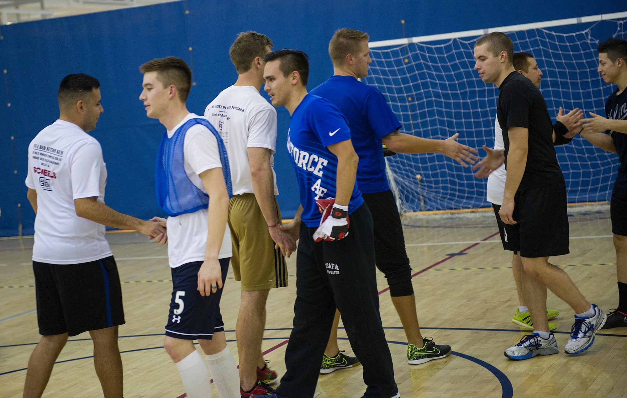 The 5th Contracting Squadron and 5th Medical Group teams shake hands after the intramural indoor soccer championship at Minot Air Force Base, N.D., Nov. 24, 2015. After coming down to penalty kicks, 5th CONS won the shootout by one goal. (U.S. Air Force photo/Senior Airman Apryl Hall)