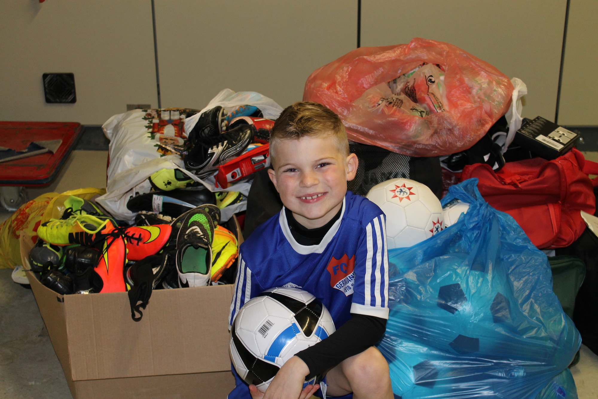 Brayden Tester, son of Chief Master Sgt. David Tester, U.S. Air Forces in Europe operations superintendent, poses in front of soccer equipment Mar. 28, 2015, at Ramstein Air Base, Germany. Brayden gathered support from around the Kaiserslautern Military Community to collect soccer equipment for Ethiopian children that his father told him “couldn’t afford shoes to play in or soccer balls to play with.” (Courtesy photo)