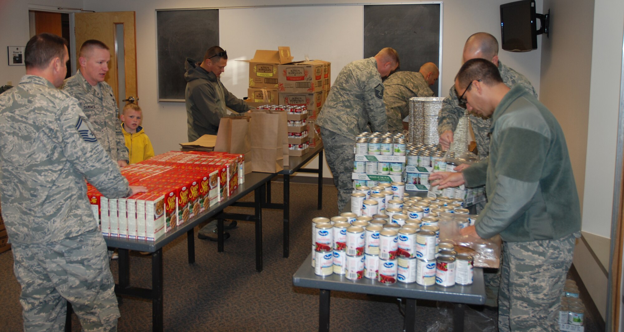 PETERSON AIR FORCE BASE, Colo. – Members of the Peterson Diamond Council form an assembly line to bag 120 Thanksgiving meals to be distributed by first sergeants to Airmen who can use the extra help this holiday season. Food items are donated by Peterson Air Force Base Commissary vendors. (U.S. Air Force photo by Dave Smith)
