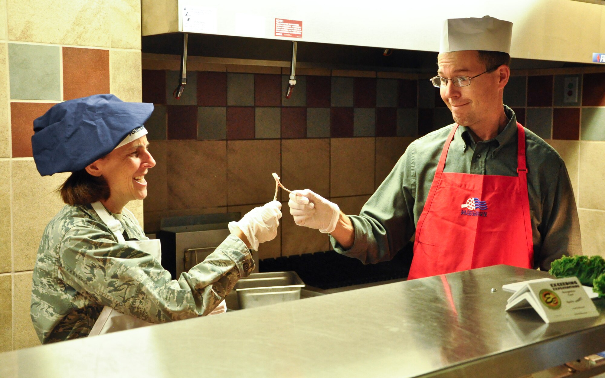 PETERSON AIR FORCE BASE, Colo. – Col. Susan Moran, 21st Medical Group commander, and her husband, Sean, break a wishbone while serving Thanksgiving meals to members of Team Pete at the Aragon Dining Facility, Nov. 2, 2015. Every year wing and group senior leadership comes together to serve Thanksgiving meals to members of Team Pete. (U.S. Air Force photo by Capt William Russell)