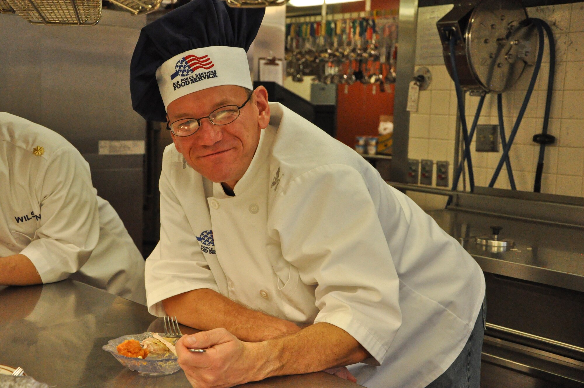 PETERSON AIR FORCE BASE, Colo. – Col. Reginald Ash III, 21st Mission Support Group commander, eats some Thanksgiving food after serving members of Team Pete during the annual event at the Aragon Dining Facility, Nov. 26, 2015. Wing and group senior leadership served four 25-pound turkeys, four 15-pound hams, 70 pounds of mashed potatoes and much more to on base Airmen who were unable to make it home for the holiday. (U.S. Air Force photo by Capt William Russell) 