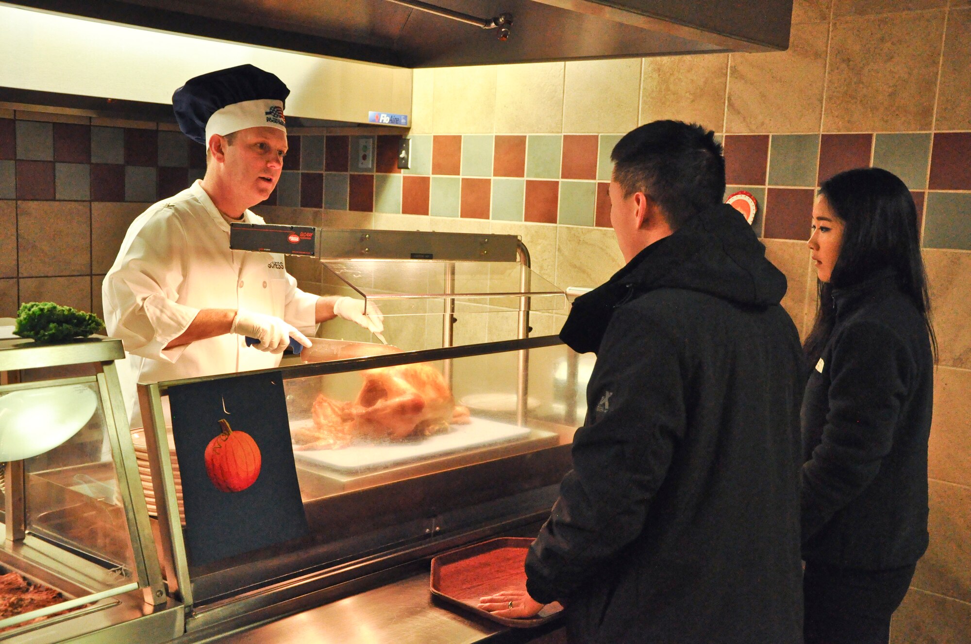 PETERSON AIR FORCE BASE, Colo. – Col. Doug Schiess, 21st Space Wing commander, carves and serves turkey to members of Team Pete at the Aragon Dining Facility, Nov. 26, 2015. Schiess, his family, wing senior leadership and their families served Thanksgiving meals to Airmen who were on base and unable to make it home for the holidays. (U.S. Air Force photo by Capt William Russell)