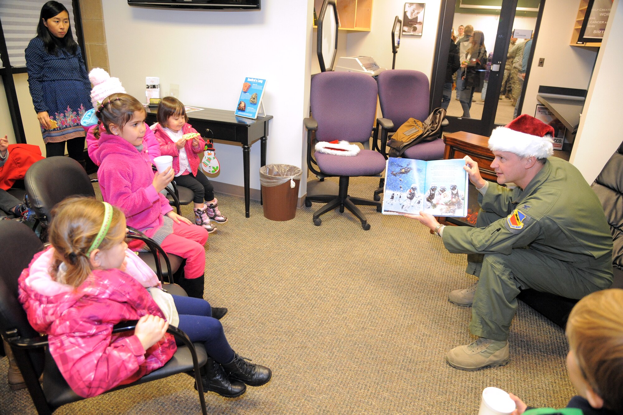Col. David Lyons, 388th Fighter Wing commander, reads to children during the Hill Air Force Base Christmas Tree Lighting Celebration Nov. 30, 2015. The annual celebration kicked off the holiday season for base personnel and their families.