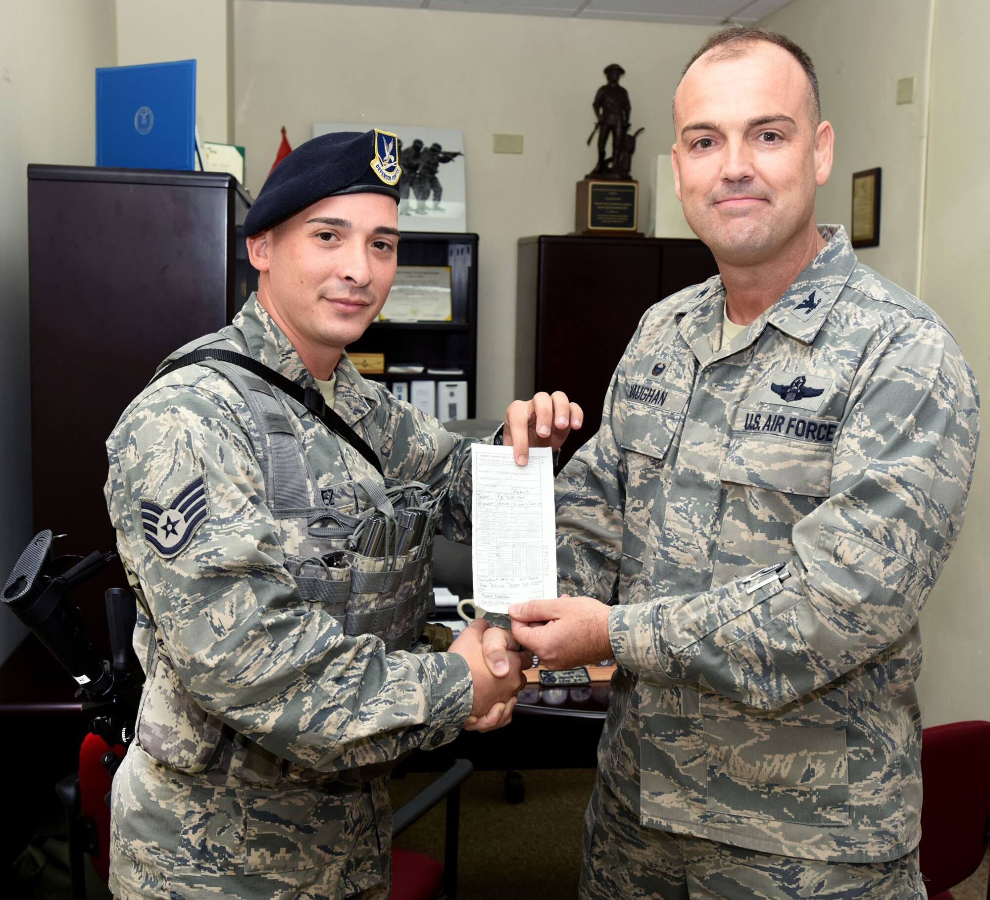 Staff Sgt. Gabriel P. Rivera, 156th Security Forces Squadron and Col. Edward L. Vaughan, 156th Airlift Wing commander, pose with a parking citation that Rivera issued to Vaughan Nov. 13, 2015, at Air National Guard Base Muñiz. Vaughan said that he's glad the use the citation as an opportunity to show that every Airman in the wing is held to the same standard. (U.S. Air National Guard photo by Tech. Sgt. Efrain Sanchez/Released)