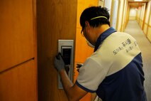A Korean national contractor sets up new smart locks in building 535 at Kunsan Air Base, Republic of Korea, Dec. 2, 2015. The dormitory buildings are being changed to a smart lock system as part of a three phase program to reduce dormitory lockouts.