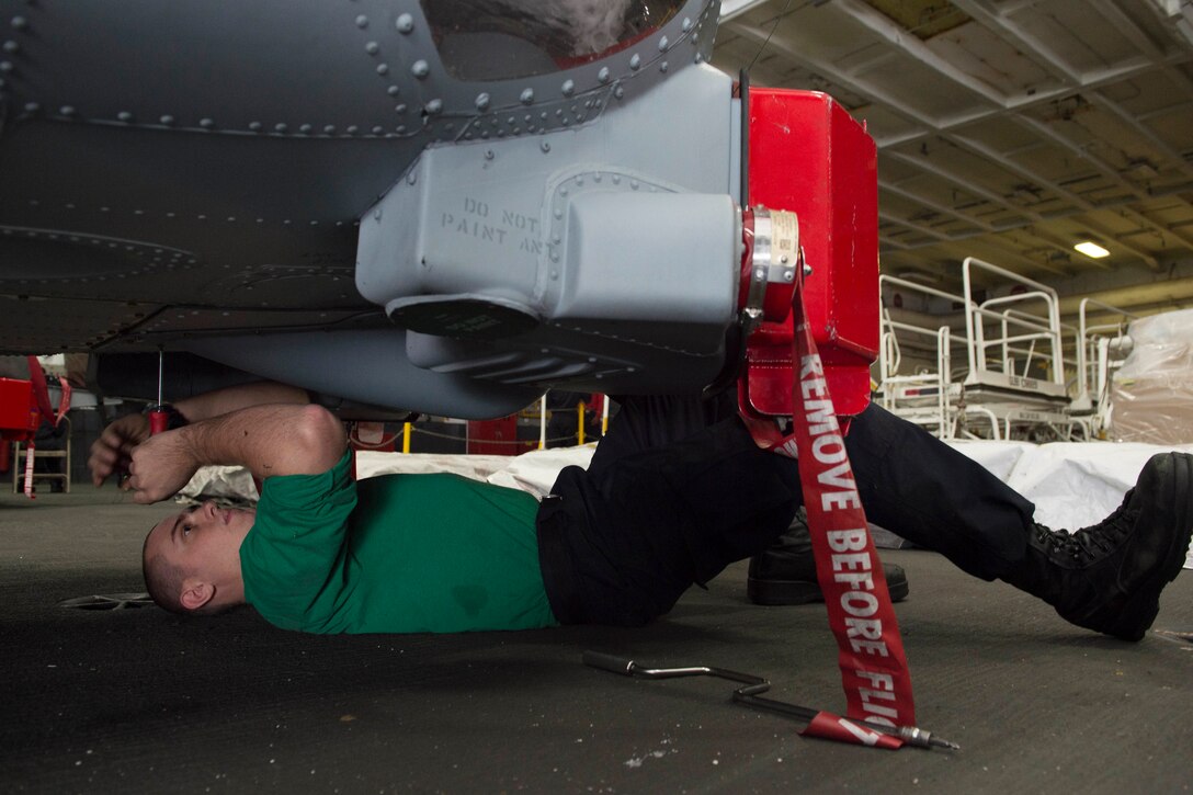 U.S. Navy Aviation Structural Mechanic Airman Nathan Christopher conducts maintenance on an MH-60R Seahawk helicopter assigned to the Swamp Foxes of Helicopter Maritime Strike Squadron 74 in the hangar bay of the aircraft carrier USS Dwight D. Eisenhower in the Atlantic Ocean, Nov. 25, 2015. U.S. Navy photo by Seaman Anderson W. Branch