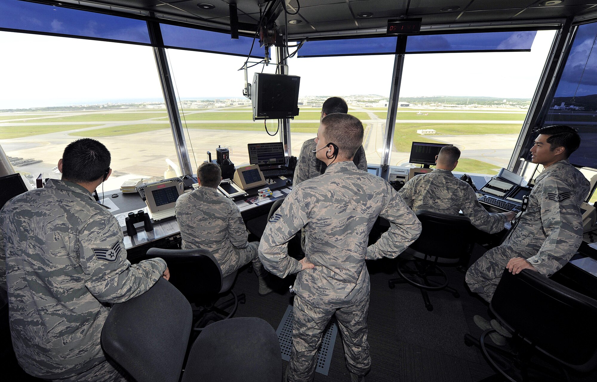 Air traffic controllers from the 18th Operations Support Squadron visually scan the Kadena flight line for safety risks in the ATC tower, Nov. 30, 2015, at Kadena Air Base, Japan. Air traffic controllers require extensive training so they can ensure the safety of flight operations for multiple airframes while minimizing delays. (U.S. Air Force photo by Naoto Anazawa/Released)