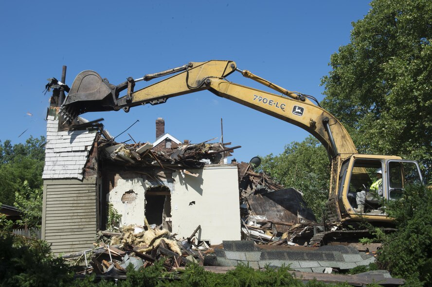 Tech. Sgt. Casey Klein, 910th Civil Engineer Squadron heavy equipment noncommissioned officer in charge, uses an excavator to demolish a house condemned by Youngstown officials, July 23, 2015. As part of the Air Force Community Partnership Program, 910th Civil Engineers received training opportunities while providing services for Youngstown including blighted structure demolition, road sign installation and neighborhood cleanup. (U.S. Air Force photo/Eric M. White)