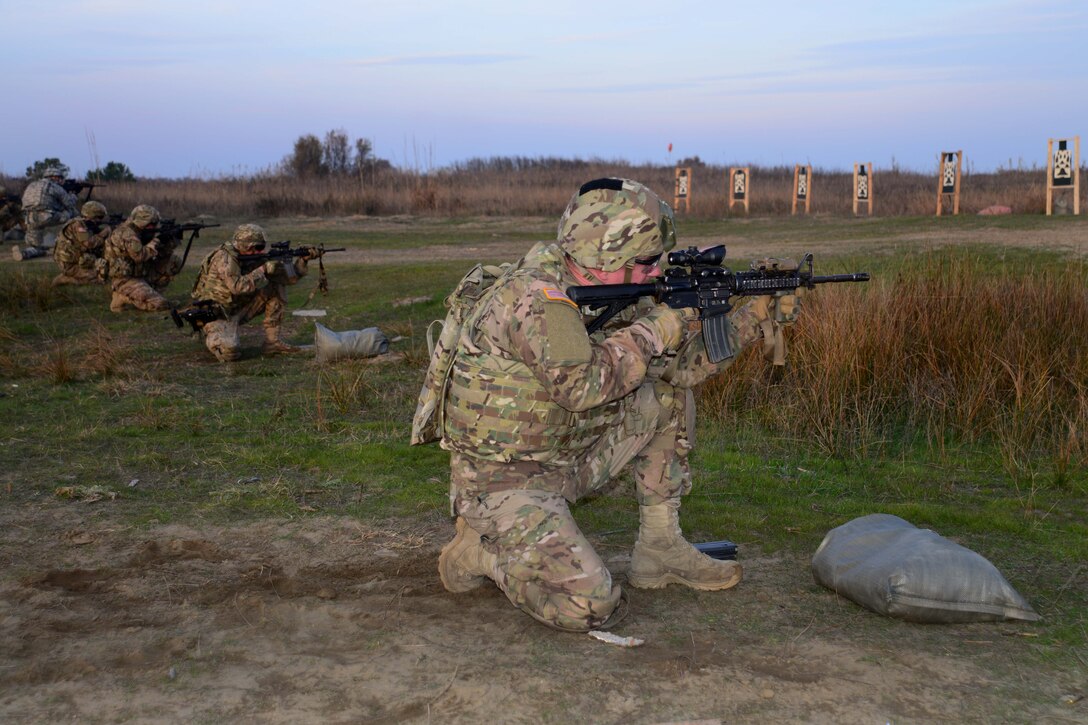 U.S. paratroopers fire from a kneeling position during M4 carbine qualification training at Force Reno Training Area, Ravenna, Italy, Nov 30, 2015. U.S. Army photo by Elena Baladelli