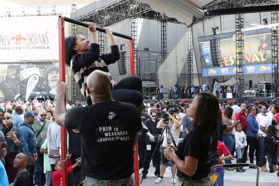 6th Marine Corps Recruiting District Marines encourage a prospect to continue her pull-ups during the Bayou Classic 2015 Fan Festival at Champions Square of the Mercedes-Benz Superdome on Nov. 28, 2015. During the Festival, the Marine Corps had a booth setup to include the Indoor Simulated Marksmanship Trainer, recruitment table and pull-up challenge. (U.S. Marine Corps photo by Sgt. Rubin J. Tan/Released)