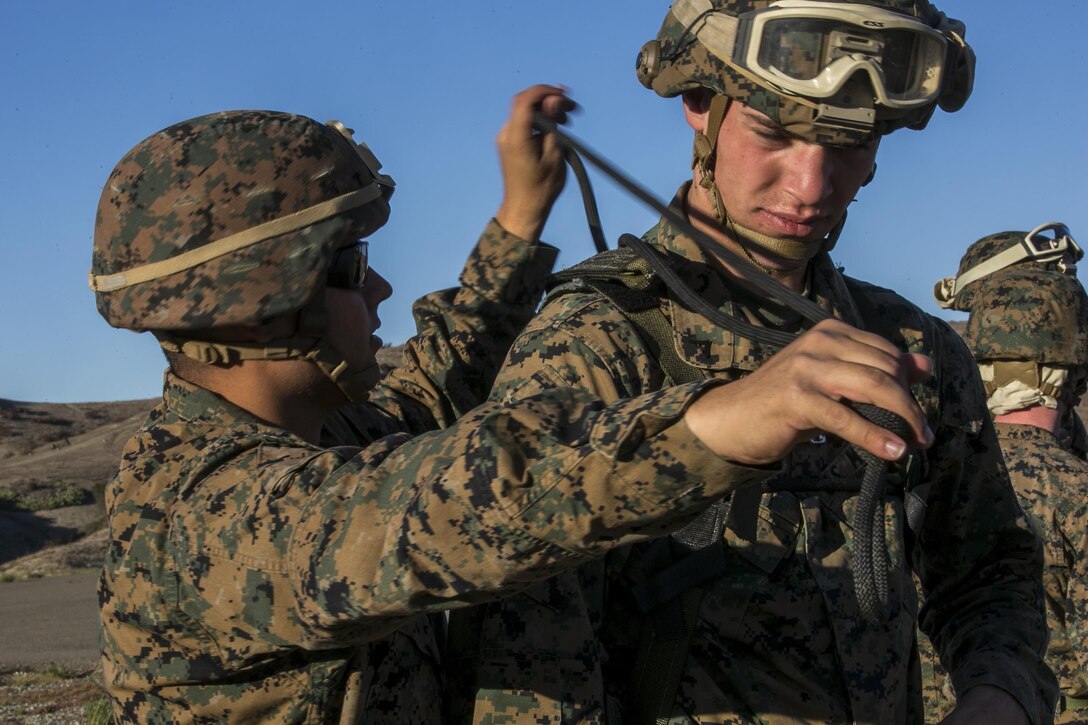 Marine Cpl. Allen Crouch and Lance Cpl. Justin Wright work together to ensure all knots are properly tied during Special Patrol Insertion and Extraction rigging training on Camp Pendleton, Calif., Nov. 19, 2015. Crouch and Wright are assigned to Golf Company, Battalion Landing Team, 13th Marine Expeditionary Unit. U.S. Marine Corps photo by Cpl. Briauna Birl