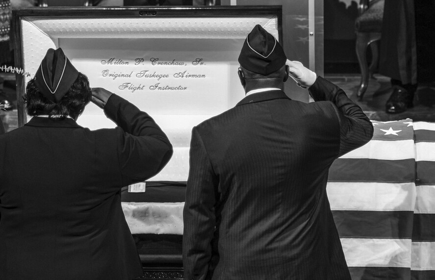 Two veterans salute the casket of Milton P. Crenchaw during a funeral service Dec. 1, 2015, at St. Mark Baptist Church in Little Rock, Ark. Crenchaw passed at the age of 96. He was a groundbreaking Tuskegee Airmen instructor and is considered to be the father of black aviation in Arkansas.