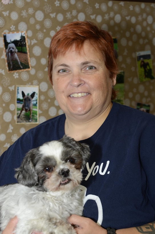 Kim K. Gunderman, the manager at the Family Pet Care Center on Fort Meade, Md., poses with Dimsum, one of the boarded dogs at the center, Sept. 17, 2015. 