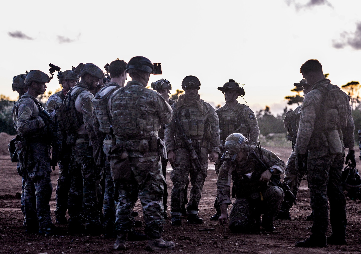 Airmen from the 320th Special Tactics Squadron gather around their team lead outside a shoot house as he discusses details of an upcoming mission Nov. 19, 2015, in Camp Hansen, Japan. Extensive planning and coordination is put into STS operations in order to maximize mission effectiveness and safety. (U.S. Air Force photo by Senior Airman John Linzmeier)
