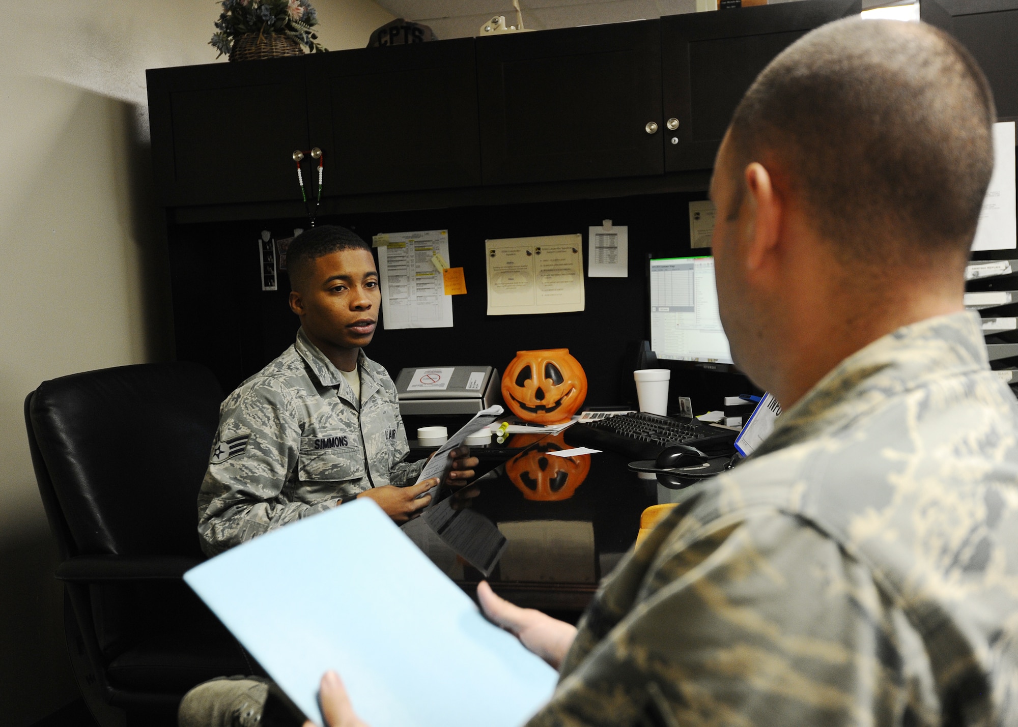 Senior Airman Mathan Simmons, 325th Comptroller Squadron financial services technician, assists and briefs an Airman before his deployment to an overseas location Nov. 25 at the Base Support Center. The Customer Support section manages the Defense Travel System, is responsible for leave management, and acts as the intermediary for non-DTS travel voucher computation serviced by the Air Force Financial Services Center. (U.S. Air Force photo by Senior Airman Ty-Rico Lea/Released)