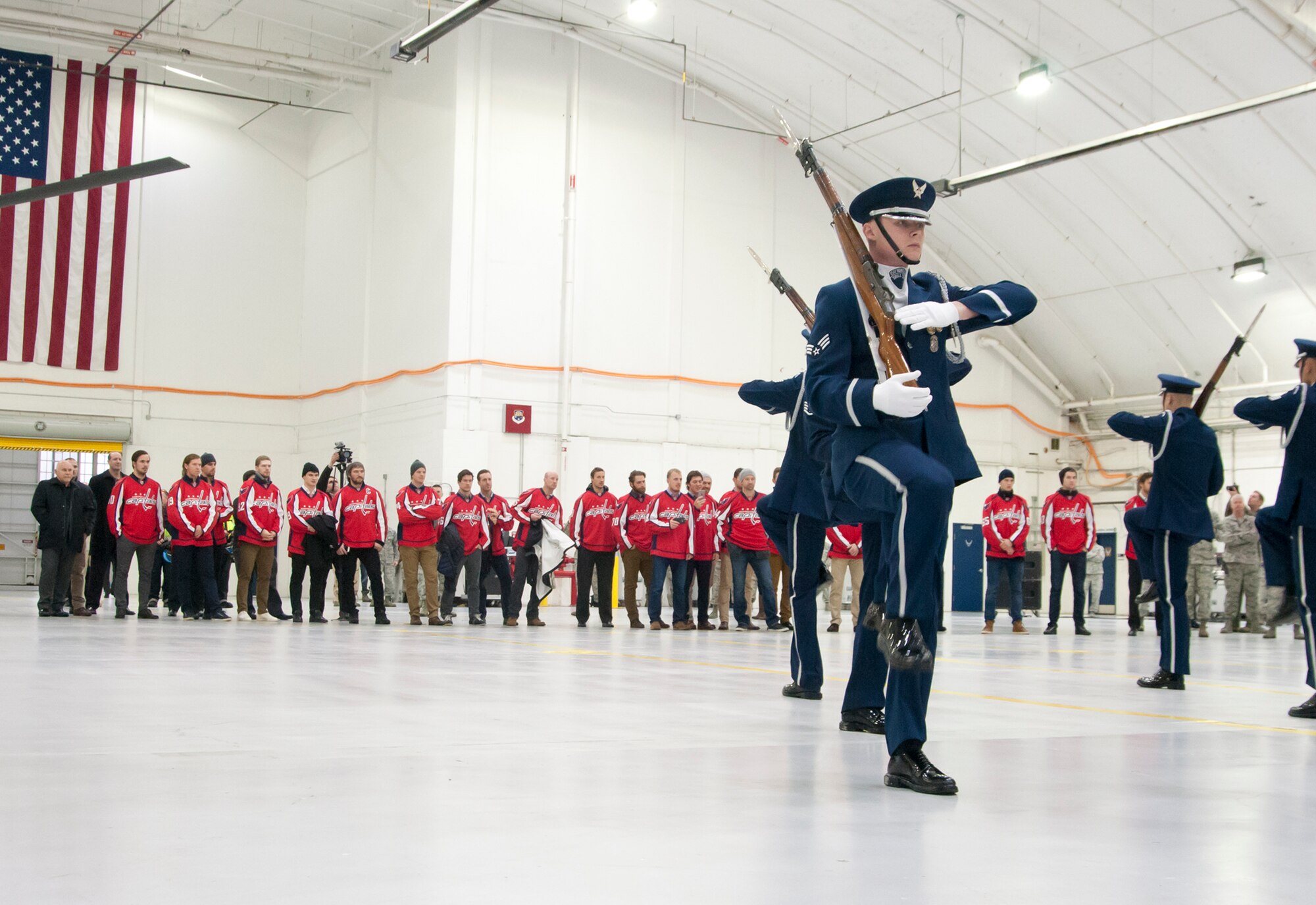 The Washington Capitals observe a performance by the US Air Force Honor Guard inside a 459th air Refueling Wing hangar on Joint Base Andrews, Md., Dec. 1, 2015. The Capitals visited JBA to learn about the Air Force mission here. They observed special performances by the U.S. Air Force band Max Impact, Honor Guard, 11th Wing Explosive Ordnance Disposal, as well as static displays from the 459 ARW, 1st Helicopter Squadron and 113th Wing, Air National Guard. (U.S. Air Force photo by Staff. Sgt. Kat Justen)