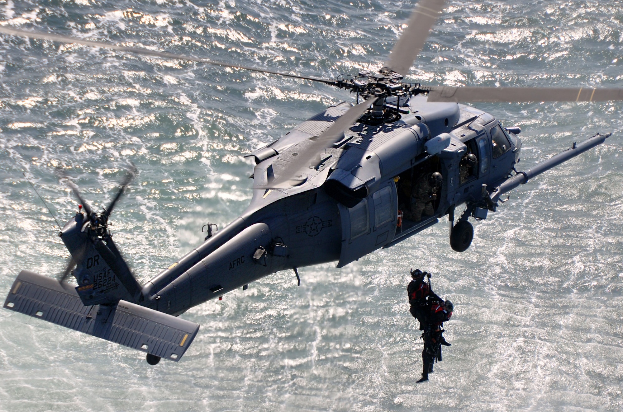Two pararescuemen from the 304th Rescue Squadron, Portland Air National Guard Base, Ore., are hoisted into an HH-60 Pave Hawk Helicopter from the 305th Rescue Squadron, Davis Monthan Air Force Base, Ariz., over the Pacific Ocean near Oregon’s northern coast May 5, 2015. The pararescuemen and helicopter crew were practicing several water rescue scenarios together. Both squadrons are geographically separated units of the 920th Rescue Wing, a combat search-and-rescue Air Force Reserve wing located at Patrick AFB, Fla. (U.S. Air Force photo by 2nd Lt. Anna-Marie Wyant)