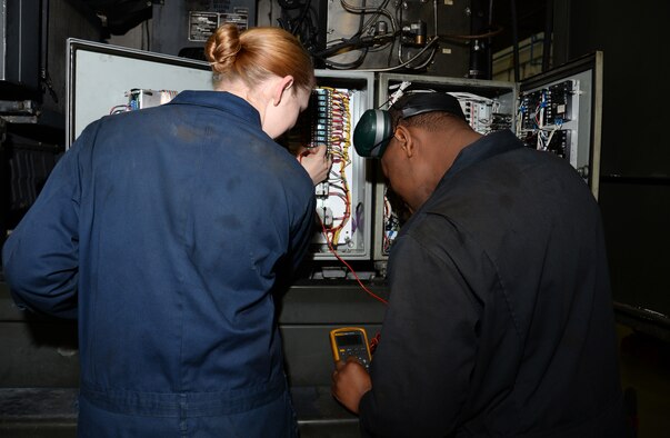 U.S. Air Force Airman 1st Class Carly Reuter, left, 100th Logistics Readiness Squadron vehicle maintenance journeyman, and U.S. Air Force Staff Sgt. Peter Musinde, 100th LRS NCO in charge of special purpose vehicle maintenance, troubleshoot the heater system on a global deicer Nov. 24, 2015, on RAF Mildenhall, England. Much of the night work is on deicers to ensure they are ready for the KC-135 Stratotankers at all times throughout the winter. (U.S. Air Force photo by Gina Randall/Released)