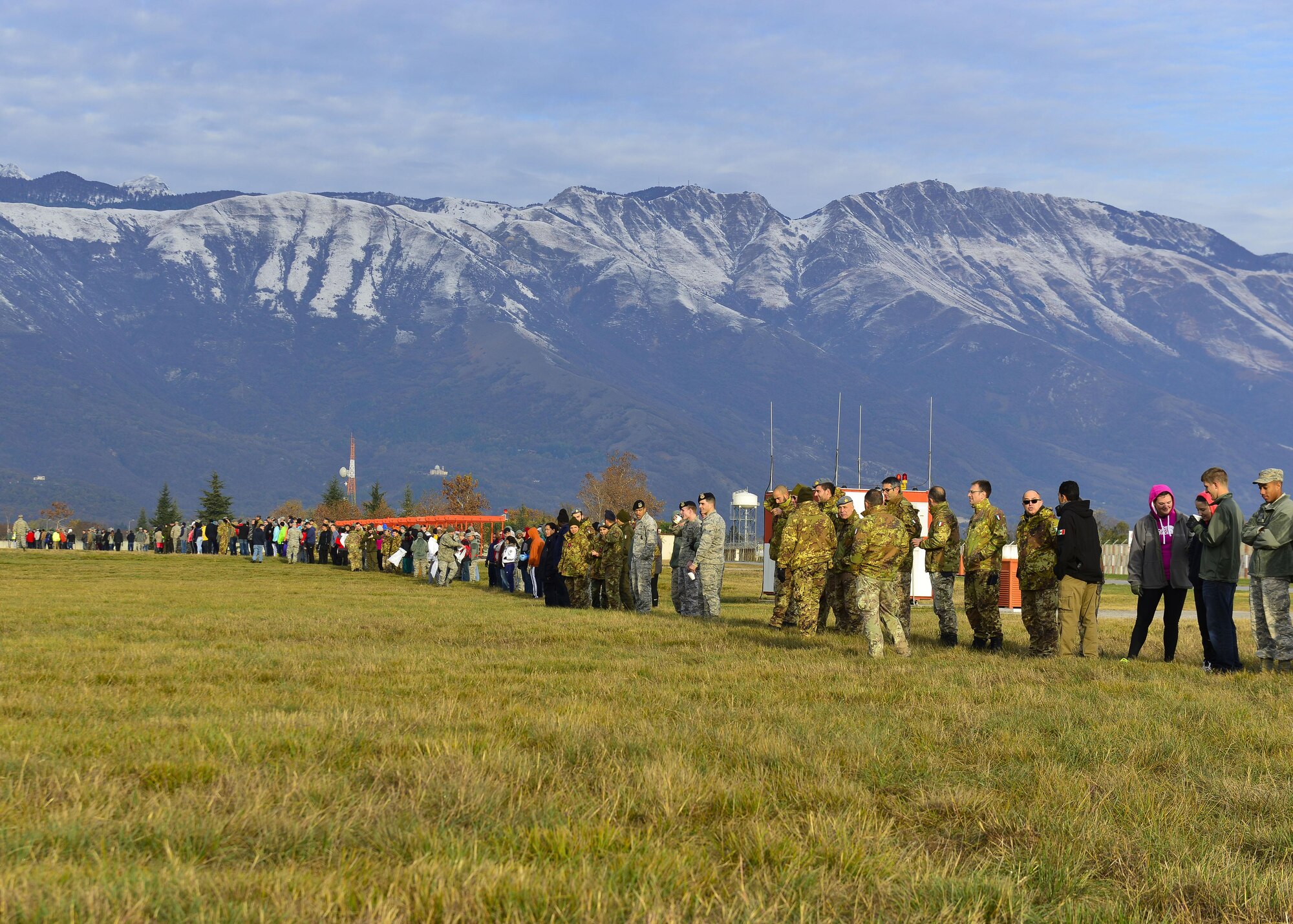 Approximately 300 U.S. and Italian volunteers line up prior to a “Rabbit Roundup” event, Nov. 25, 2015, at Aviano Air Base, Italy. The volunteers were tasked with corralling rabbits on the flight line into nets for relocation purposes. (U.S. Air Force photo by Airman 1st Class Cary Smith/Released)