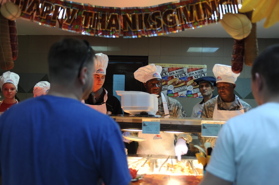 Chief Master Sgt. Vegas Clark, 39th Air Base Wing command chief, serves Thanksgiving meals to Airmen at the Sultan’s Inn dining facility Nov. 26, 2015, at Incirlik Air Force Base, Turkey. Dining facility workers prepared a traditional Thanksgiving meal and base leaders and their families served permanent party and deployed Airmen for lunch. (U.S. Air Force photo by Airman 1st Class Daniel Lile/Released)