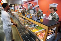 U.S. Air Force Airman 1st Class Calvin Tynes, a food service specialist with the 509th Force Support Squadron, is served by members of the base leadership during the annual Thanksgiving meal at the Ozark Inn Dining Facility at Whiteman Air Force Base, Mo., Nov. 26, 2015. The dining facility staff prepared a special Thanksgiving Day meal, set up decorations and offered specialty cakes and desserts. (U.S. Air Force photo by Airman 1st Class Jazmin Smith)