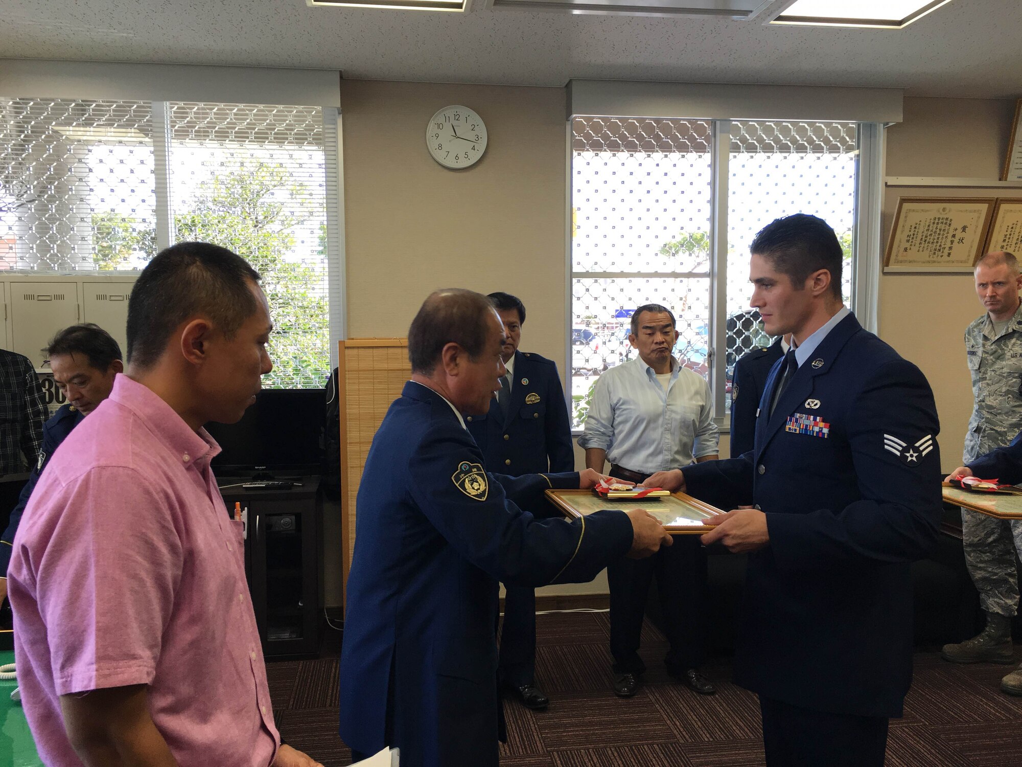 U.S. Air Force Senior Airman Matthew Wojciechowski, 18th Civil Engineer Squadron electrical systems journeyman, receives a certificate of appreciation from Hajime Shinzato, Okinawa Police Station chief, Nov. 30, 2015, at Okinawa Police Station, Okinawa, Japan. Wojciechowski and another Airmen were recognized for stopping a robbery at a liquor store. (Courtesy photo)