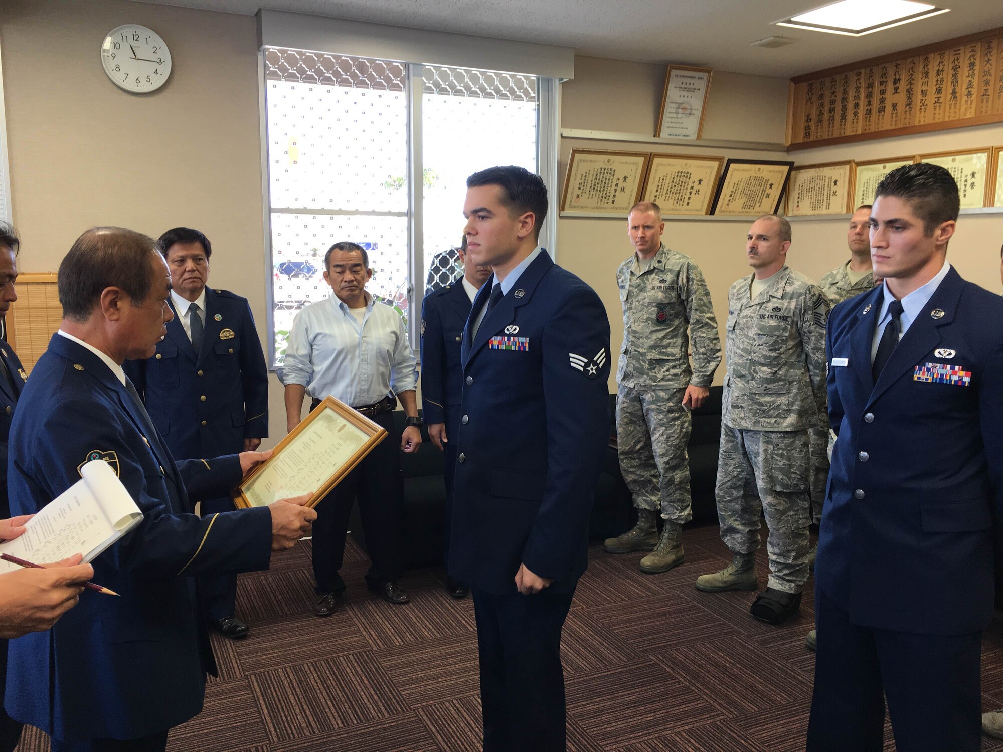 U.S. Air Force Senior Airman Luke Fyke, 18th Civil Engineer Squadron electrical systems journeyman, receives a certificate of appreciation from Hajime Shinzato, Okinawa Police Station chief, Nov. 30, 2015, at Okinawa Police Station, Okinawa, Japan. The Airmen were recognized for helping detain robbery suspects and holding them until police arrived at the scene. (Courtesy photo)