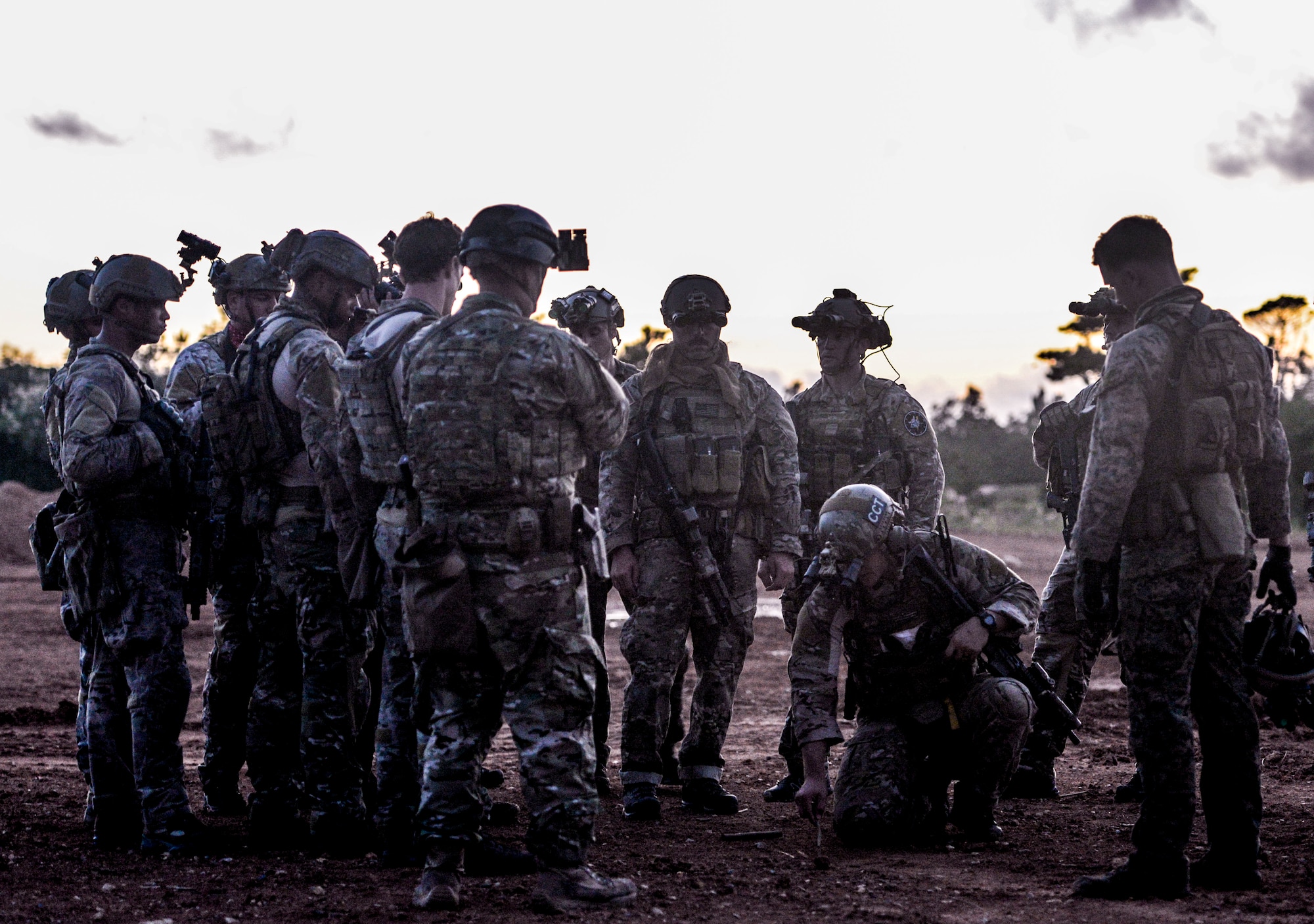 Airmen from the 320th Special Tactics Squadron gather around their team lead outside a shoot house as he discusses details of an upcoming mission Nov. 19, 2015, in Camp Hansen, Japan. Extensive planning and coordination is put into STS operations in order to maximize mission effectiveness and safety. (U.S. Air Force photo by John Linzmeier)