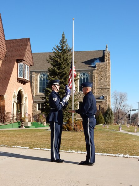 120th Airlift Wing Base Honor Guard member Staff Sgt. Trevor Livingston presents a folded flag to Maj. Rick Anderson during a practice event prior to performing military funeral honors Nov. 19, 2015. (U.S. Air National Guard photo by Senior Master Sgt. Eric Peterson/Released)