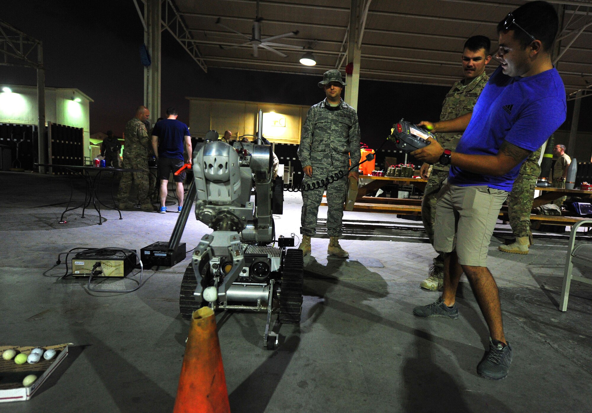 A 380th Air Expeditionary Wing Airman attempts to place a golf ball inside a cone as part of the Drive the Robot Challenge during an Explosive Ordnance Disposal Capabilities Carnival at an undisclosed location in Southwest Asia, Nov. 27, 2015. Other events held during the carnival included the Wear the Bomb Suit, Disarm the Bomb and Bomb Suit Pushup Challenge. (U.S. Air Force photo by Staff Sgt. Kentavist P. Brackin/Released)