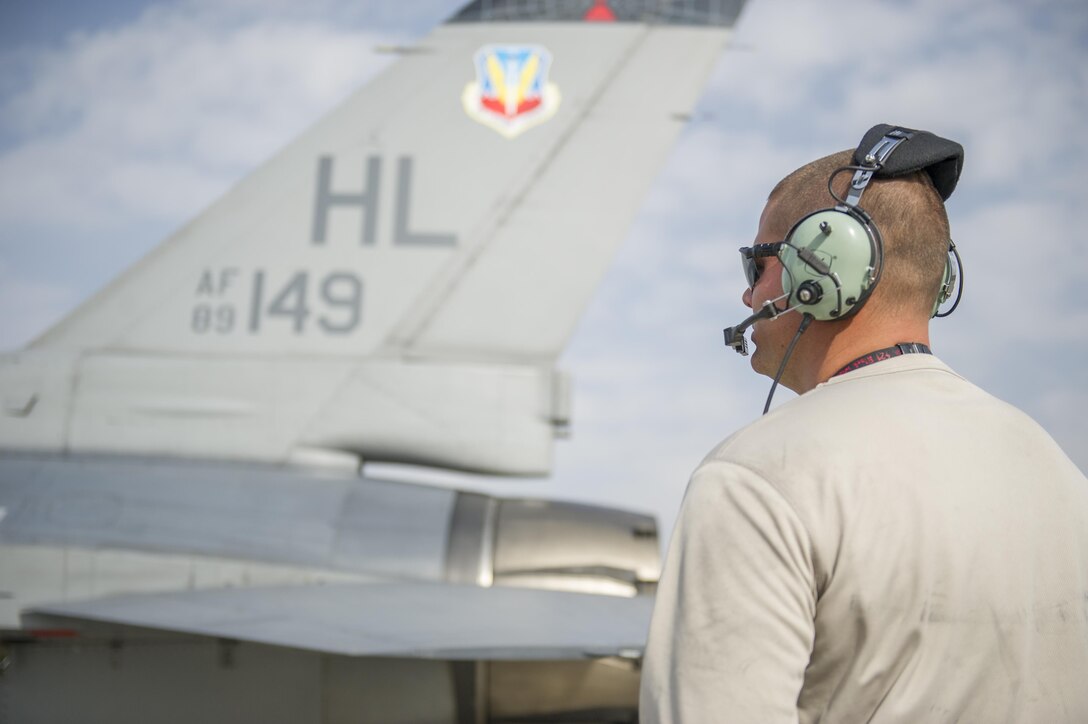Staff Sgt. Steven Concepcion, 455th Expeditionary Aircraft Maintenance Squadron crew chief, deployed from Hill Air Force Base, Utah, looks on as an F-16 Fighting Falcon starts up during a hydraulic leak repair at Bagram Airfield, Afghanistan, Nov. 30, 2015. The squadron provides combat-ready aircraft to the air component commander in support of coalition forces throughout Afghanistan. (U.S. Air Force Photo by Tech. Sgt. Robert Cloys/Released)