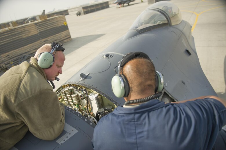 Senior Airman Jason Miranda, left, Tech. Sgt. Carlo Patalinghug, 455th Expeditionary Aircraft Maintenance Squadron crew chiefs, deployed Hill Air Force Base, Utah, examine an F-16 Fighting Falcon while repairing a hydraulic leak on the aircraft's leading edge flap at Bagram Airfield, Afghanistan, Nov. 30, 2015.  The squadron provides combat-ready aircraft to the air component commander in support of coalition forces throughout Afghanistan. (U.S. Air Force Photo by Tech. Sgt. Robert Cloys/Released)