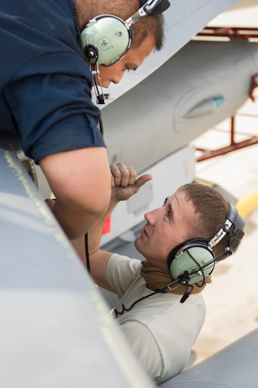 Airman 1st Class Drew Owens, right, 455th Expeditionary Aircraft Maintenance Squadron crew chief, deployed Hill Air Force Base, Utah, gives a thumbs up to Tech. Sgt. Carlo Patalinghug, 455th EAMXS crew chief, during a hydraulic leak repair on an F-16 Fighting Falcon at Bagram Airfield, Afghanistan, Nov. 30, 2015.  The squadron provides combat-ready aircraft to the air component commander in support of coalition forces throughout Afghanistan. (U.S. Air Force Photo by Tech. Sgt. Robert Cloys/Released)