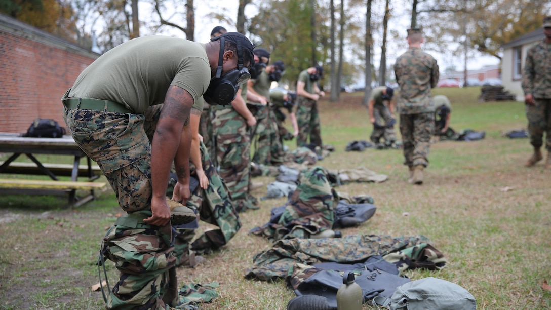 Marines with 2nd Transport Support Battalion get dressed in Mission Oriented Protective Posture gear during chemical, biological, radioactive and nuclear defense training held at Marine Corps Base Camp Lejeune, N.C., Dec. 1, 2015. Marines applied information obtained in classes about an active chemical threat and the proper protective equipment to decontaminate themselves in a CBRN situation.