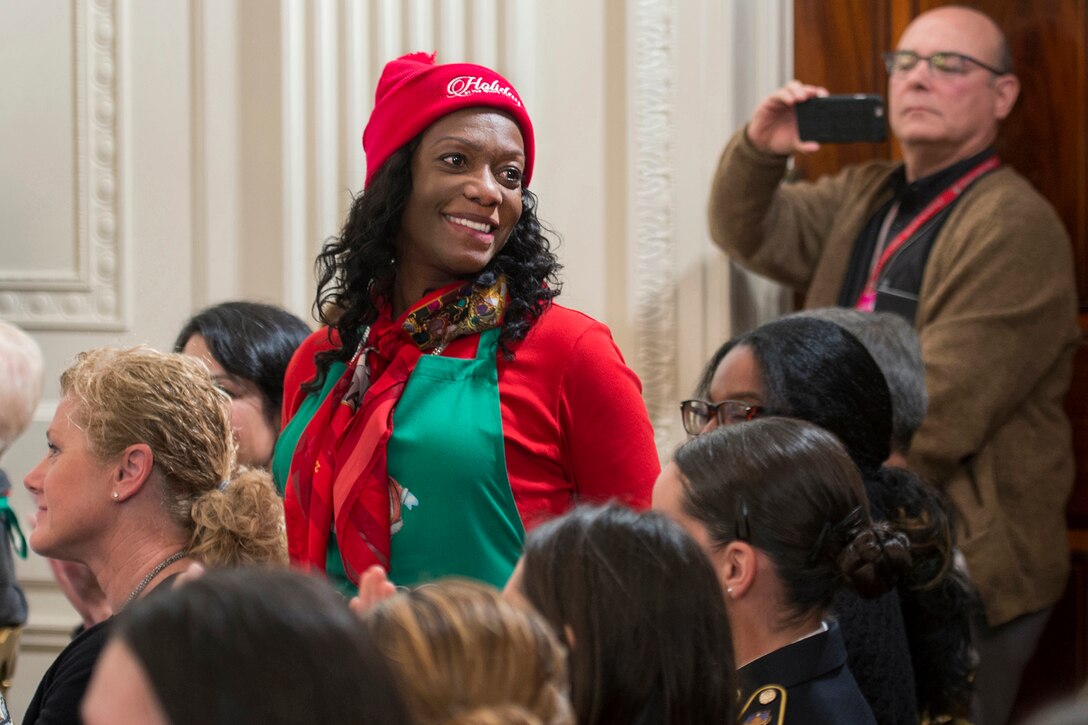 Andrea Marks, a 30-year Army veteran with combat experience, stands to be recognized as First Lady Michelle Obama recognizes her at the White House in Washington, D.C. Dec. 2, 2015. Marks volunteered for the event that gave military families the first look at the holiday decorations. DoD photo by EJ Hersom