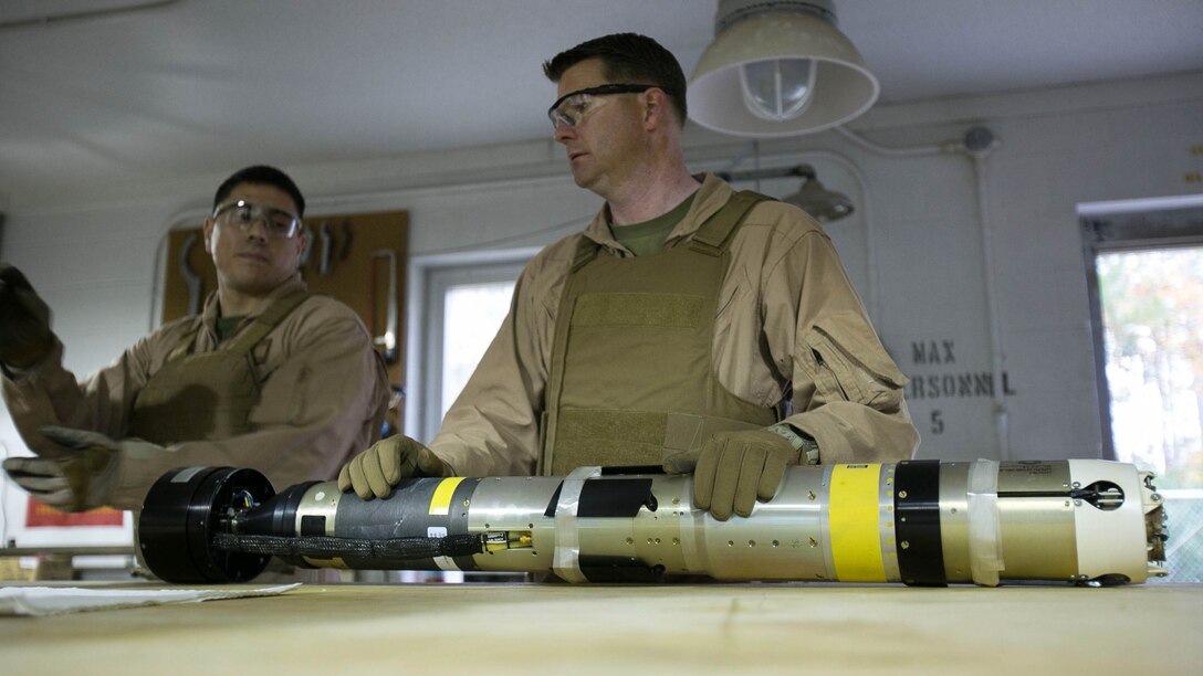 Chief Warrant Officer 2 Jason Scarborough, center, and Master Sgt. Jerry Slattum, both Explosive Ordnance Disposal technicians with EOD Company, diagnose the Griffin missile to reassure that the missile is safe to operate on at Marine Corps Base Camp Lejeune, N.C., Dec. 1, 2015. Marines with EOD constantly work to develop procedures and familiarize themselves with new ordnance.