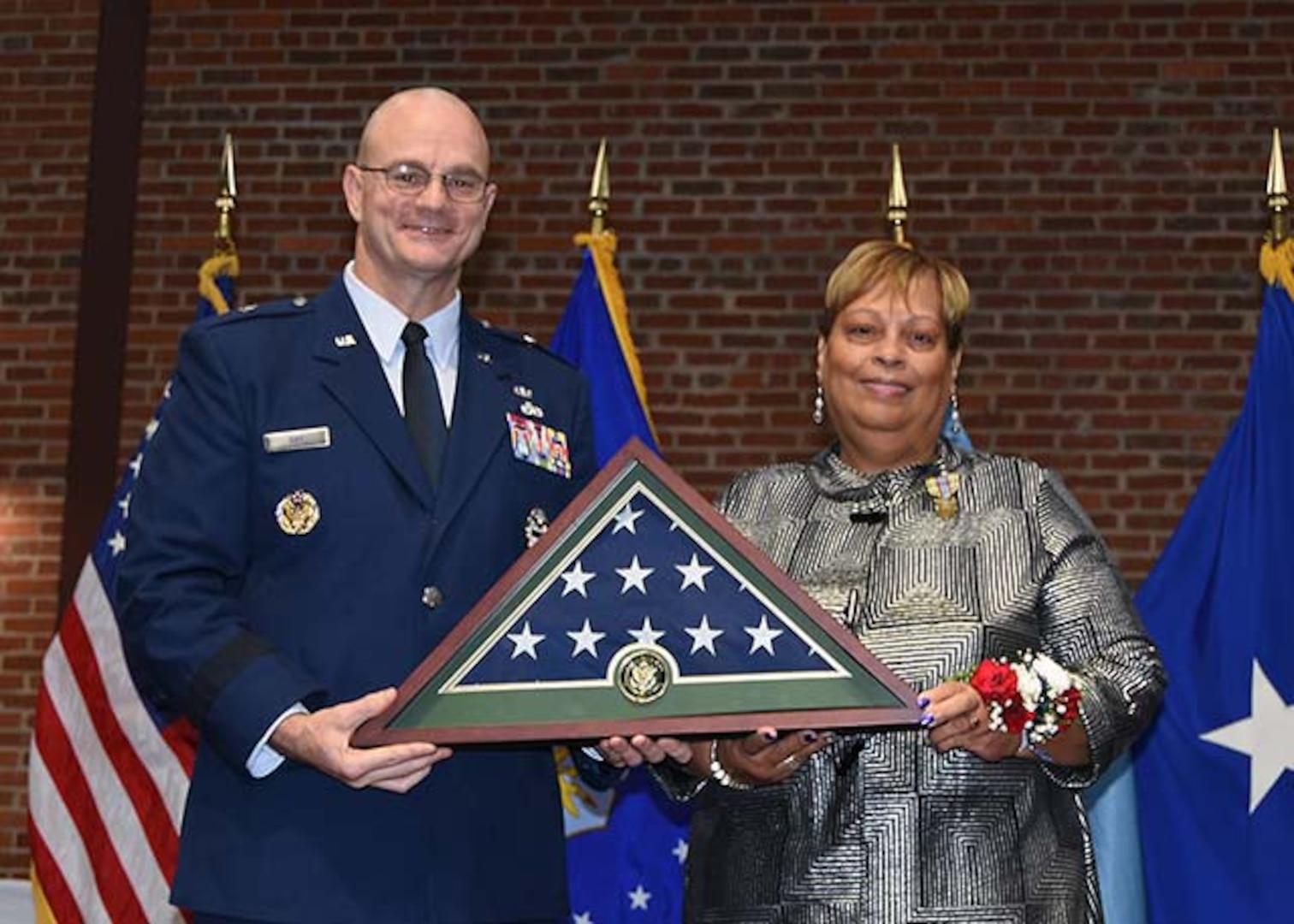 DLA Aviation Commander Air Force Brig. Gen. Allan Day, presents Lucy Lewis, president of the American Federation of Government Employees Local 1992, with an American Flag during a ceremony Nov. 24, 2015 in the Frank B. Lotts Conference Center. The flag was flown over Defense Supply Center Richmond in her honor on the occasion of her retirement from federal service after 41 years.