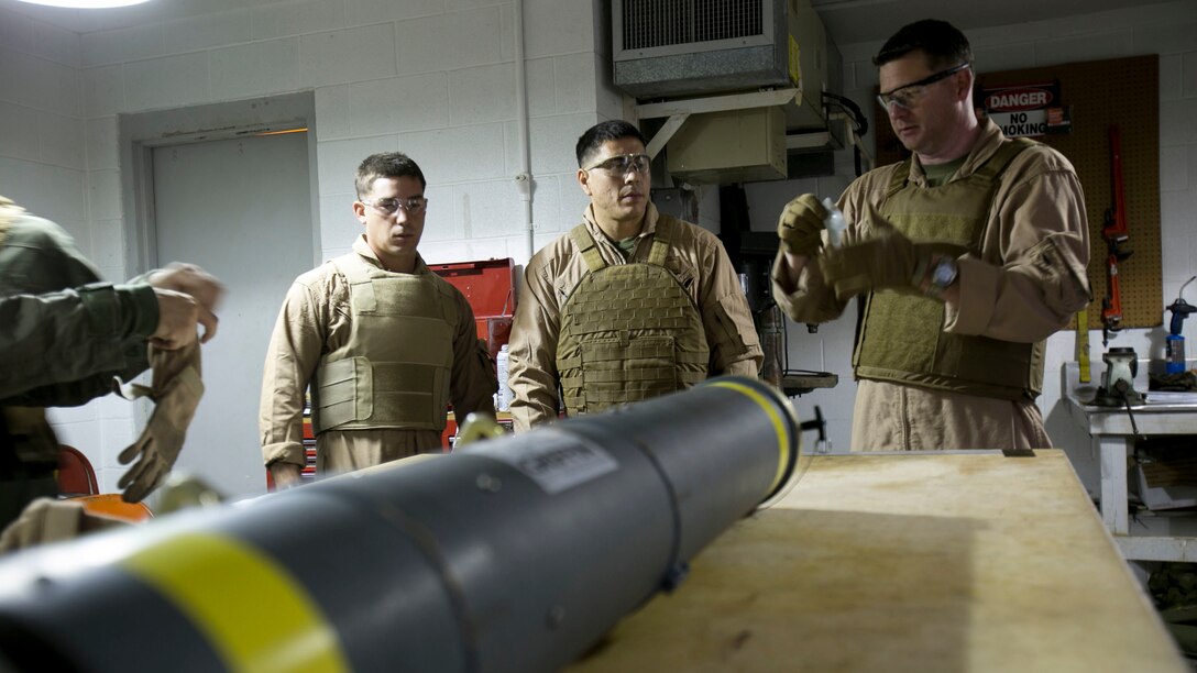 Chief Warrant Officer 2 Jason Scarborough, right, Master Sgt. Jerry Slattum, center, and Sgt. Ralph Confortini, all Explosive Ordnance Disposal technicians with EOD Company, finish donning personal protective equipment before disarming the Griffin missile at Marine Corps Base Camp Lejeune, N.C., Dec. 1, 2015. A Griffin missile is an air and ground-launched, precise, low collateral-damage missile used for irregular warfare operations. 