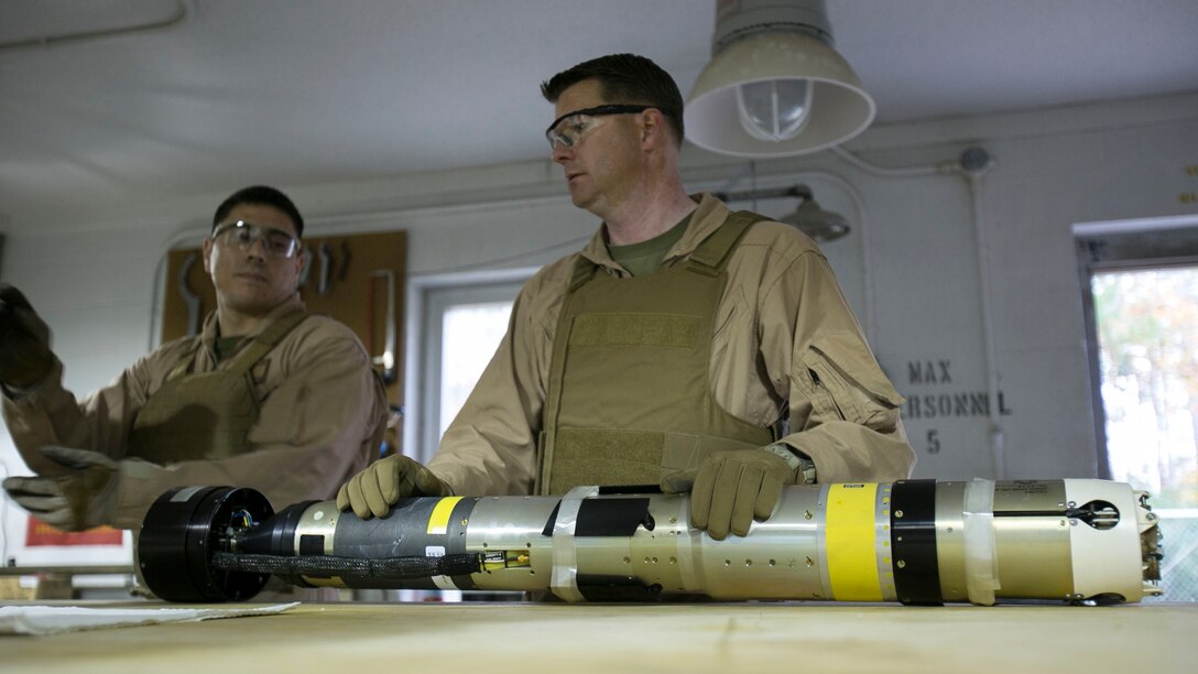 Chief Warrant Officer 2 Jason Scarborough, center, and Master Sgt. Jerry Slattum, both Explosive Ordnance Disposal technicians with EOD Company, diagnose the Griffin missile to reassure that the missile is safe to operate on at Mairne Corps Base Camp Lejeune, N.C., Dec. 1, 2015. Marines with EOD constantly work to develop procedures and familiarize themselves with new ordnance. 