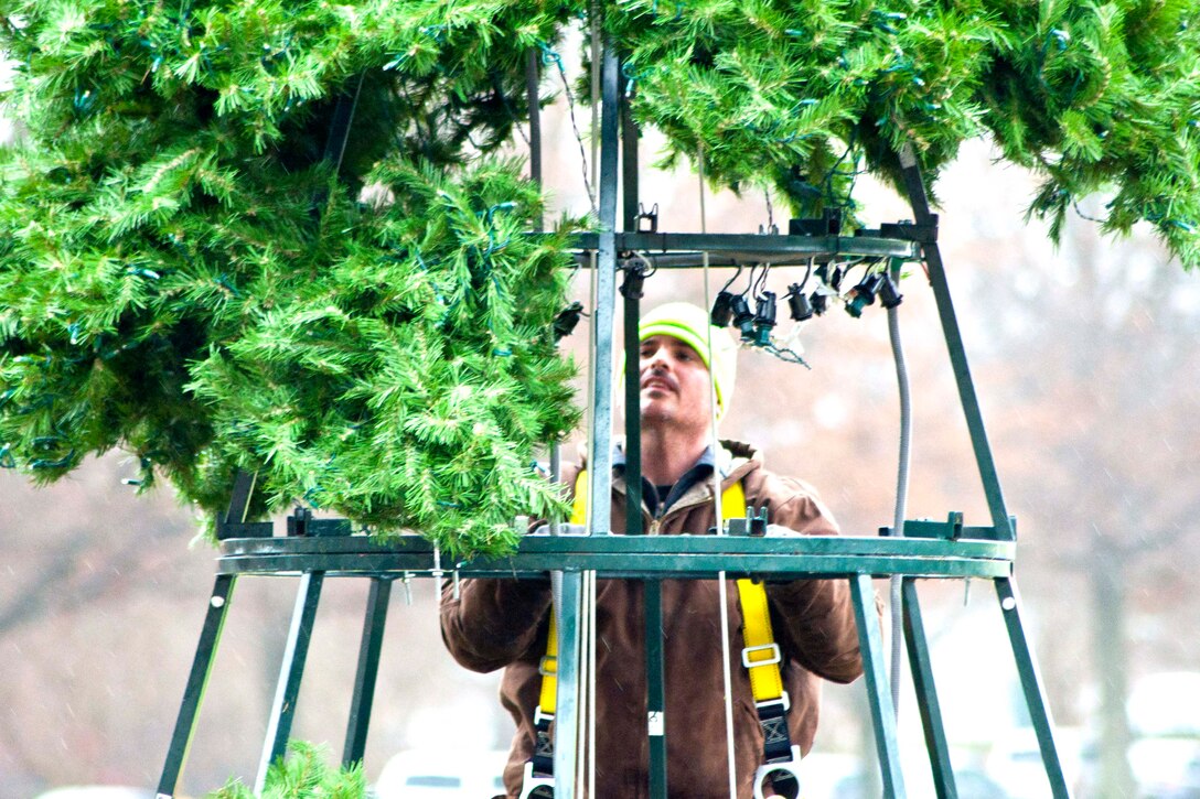 Dustin Pritchett, Marine Corps Community Service Buildings and Grounds employee, installs a 25-foot holiday tree in front of Lejeune Hall aboard Marine Corps Base Quantico, Nov. 30. Burchell, a Woodford, Va. native, has worked on base for approximately 15 years.
