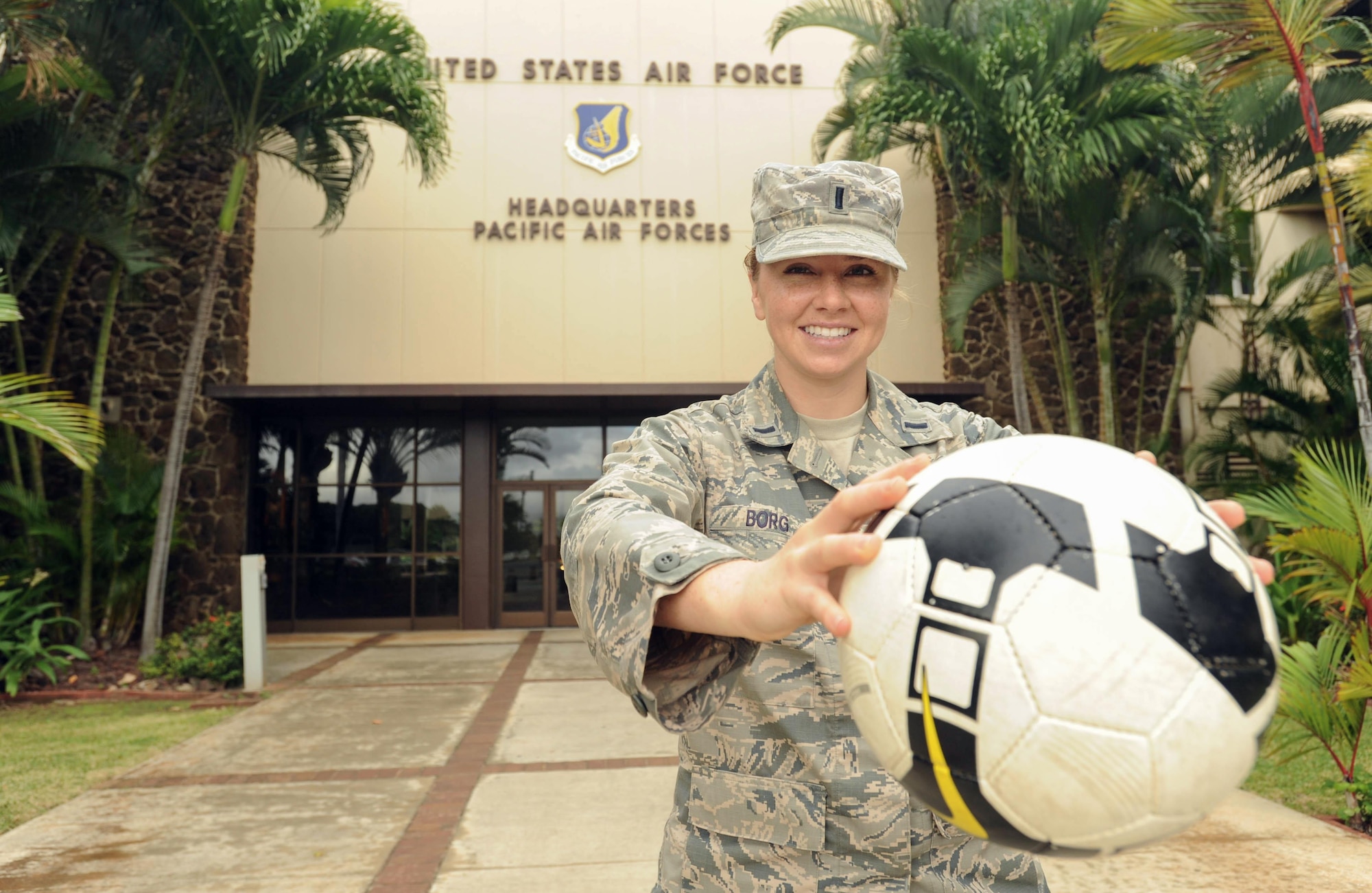 U.S. Air Force 1st Lt. Charity Borg, Headquarters Pacific Air Forces Protocol officer, poses with her soccer ball after returning from the Royal Air Force's AIRCOM Indoor Football Championship in the United Kingdom, Nov. 30, 2015, Joint Base Pearl Harbor-Hickam, Hawaii. Borg, goalie and captain for the U.S. Air Force women's team, was recruited to play after a long hiatus away from the sport, and the team took bronze in the tournament. (U.S. Air Force photo by Tech. Sgt. Amanda Dick/Released)