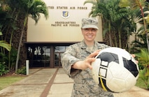 U.S. Air Force 1st Lt. Charity Borg, Headquarters Pacific Air Forces Protocol officer, poses with her soccer ball after returning from the Royal Air Force's AIRCOM Indoor Football Championship in the United Kingdom, Nov. 30, 2015, Joint Base Pearl Harbor-Hickam, Hawaii. Borg, goalie and captain for the U.S. Air Force women's team, was recruited to play after a long hiatus away from the sport, and the team took bronze in the tournament. (U.S. Air Force photo by Tech. Sgt. Amanda Dick/Released)