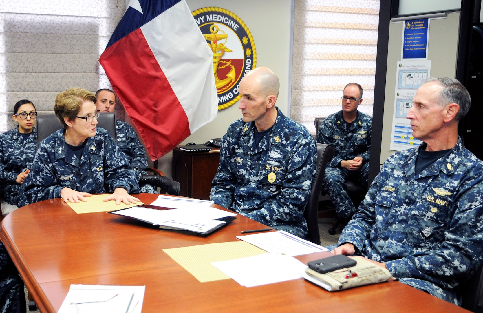 Rear Adm. Rebecca McCormick-Boyle (left), commander, Navy  Medicine Education and Training Command, gives Force Master Chief Terry Prince (second from right), Navy Medicine, a command brief. Prince visited different Navy Medicine commands in San  Antonio to talk to leaders and Sailors Nov. 16-18.
