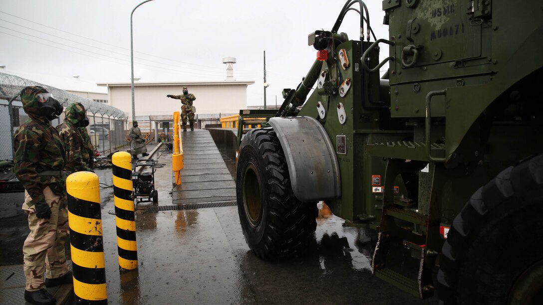 Reconnaissance, surveillance and decontamination Marines organize a decontamination line for a John Deere TRAM 624KR tractor during a simulated chemical attack at the Marine Wing Support Squadron 171 motor transportation wash rack at Marine Corps Air Station Iwakuni, Japan, Nov. 18, 2015. As part of an operational decontamination exercise, this mock attack refreshes RSD personnel’s skills in a chemical, biological, radiological and nuclear environment while preparing them for potential real world situations.