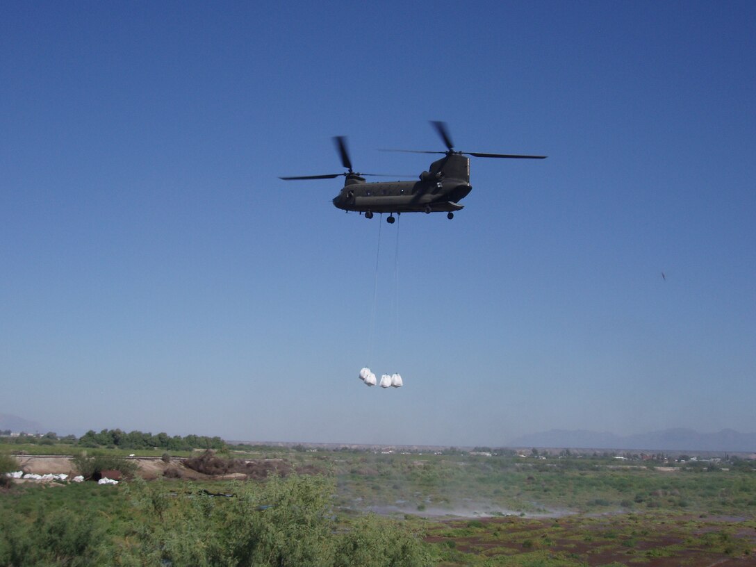 Chinook Helicopters assist in flood fighting operations along the Rio Grande at Presidio, Texas, Sept. 22, 2008. Each sand bag shown is approx. 3’ x 3’ x 3’ (one cubic yard) and weighed from 2,500 to 3,000 pounds. Photo by Steve Boberg.   