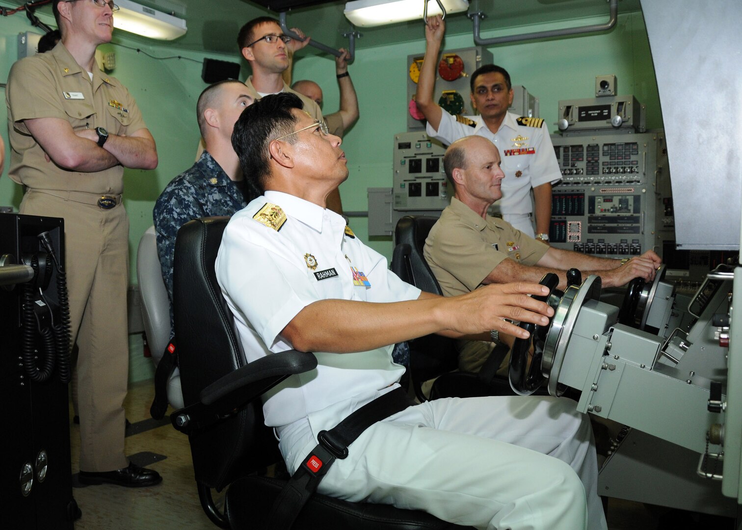 Rear Adm. Abdul Rahman, commander, Royal Malaysian Navy Submarine Force, center, and Rear Adm. William Merz, commander, Submarine Group Seven, operate a submarine dive simulator during a tour of submarine training facilities at Submarine Squadron 15, Dec 1. The simulator was just one of many scheduled events centered around submarine staff talks between the two nations. The purpose of the talks was to discuss various opportunities were the submarine forces of both nations can train and exercise together.