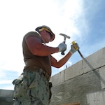 Builder 3rd Class Justin Weeks, assigned to Naval Mobile Construction (NMCB) 1, chips block on a project in the southern end of U.S. Garrison on Kwajalein Atoll (USAG-KA), Republic of Marshall Islands, Nov. 14, 2015. NMCB 1 is collaborating with the Public Works Department of the USAG-KA on the construction of shower and restroom facilities for Marshallese laborers of Kwajalein Atoll during NMCB 1’s deployment to provide humanitarian aid to the Republic of Marshall Islands.