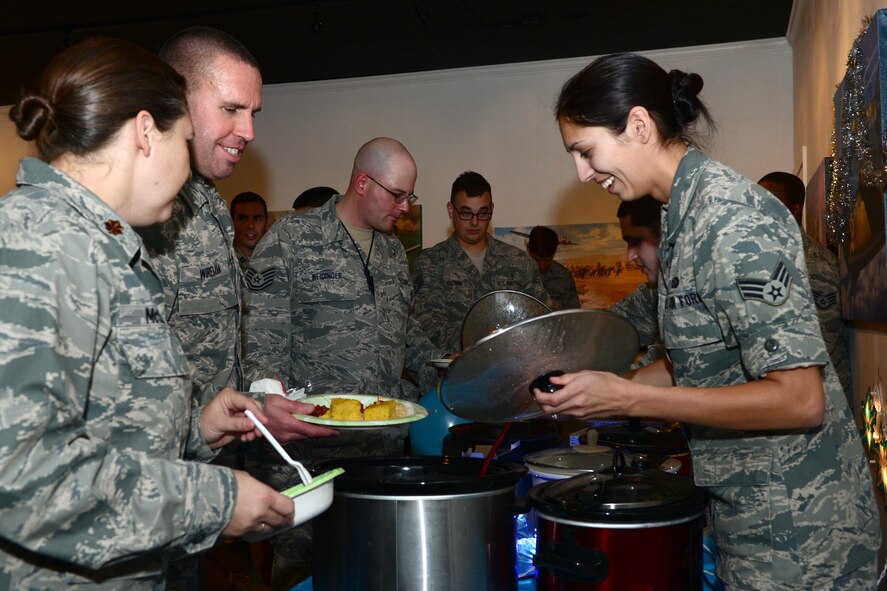 Airmen fill their plates with food during the Mighty Eighth Festivus celebration at Barksdale Air Force Base, La., Dec. 2, 2015. Visitors gathered food and treats from eight tables, each with a unique theme.  (U.S. Air Force photo/Senior Airman Benjamin Raughton)