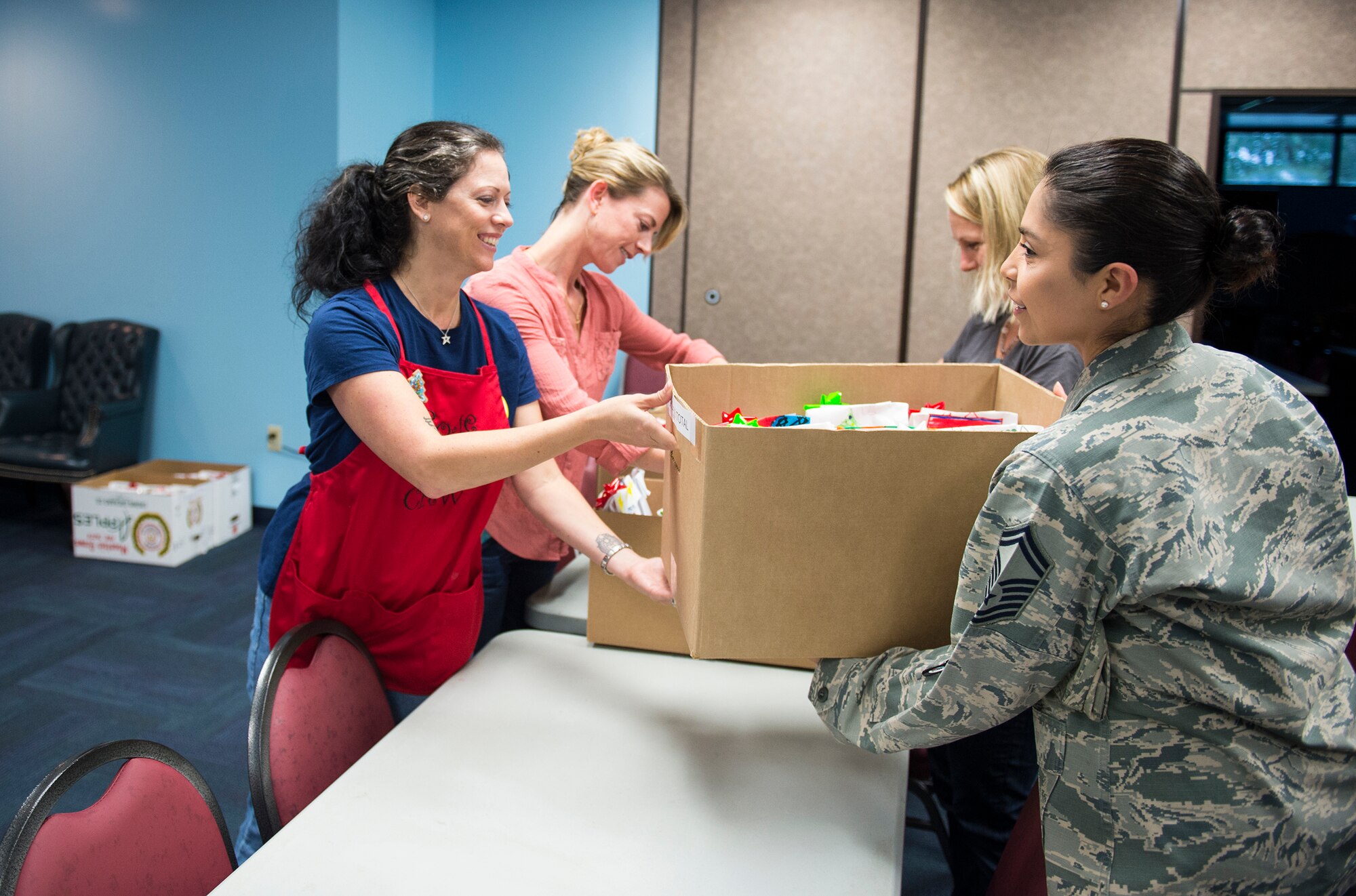 Rachel Sumja, left, cookie drive event coordinator, hands a box of cookies to Senior Master Sgt. Mary Twitty, 23d Contracting Squadron first sergeant, during the Annual Airmen’s Cookie Drive, Dec. 2, 2015, at Moody Air Force Base, Ga. Sumja, said “although Airmen can easily go to the Base Exchange for cookies, it is still important to give Airmen something made with a personal touch and a taste of home.” (U.S. Air Force photo by Senior Airman Ceaira Tinsley/Released)